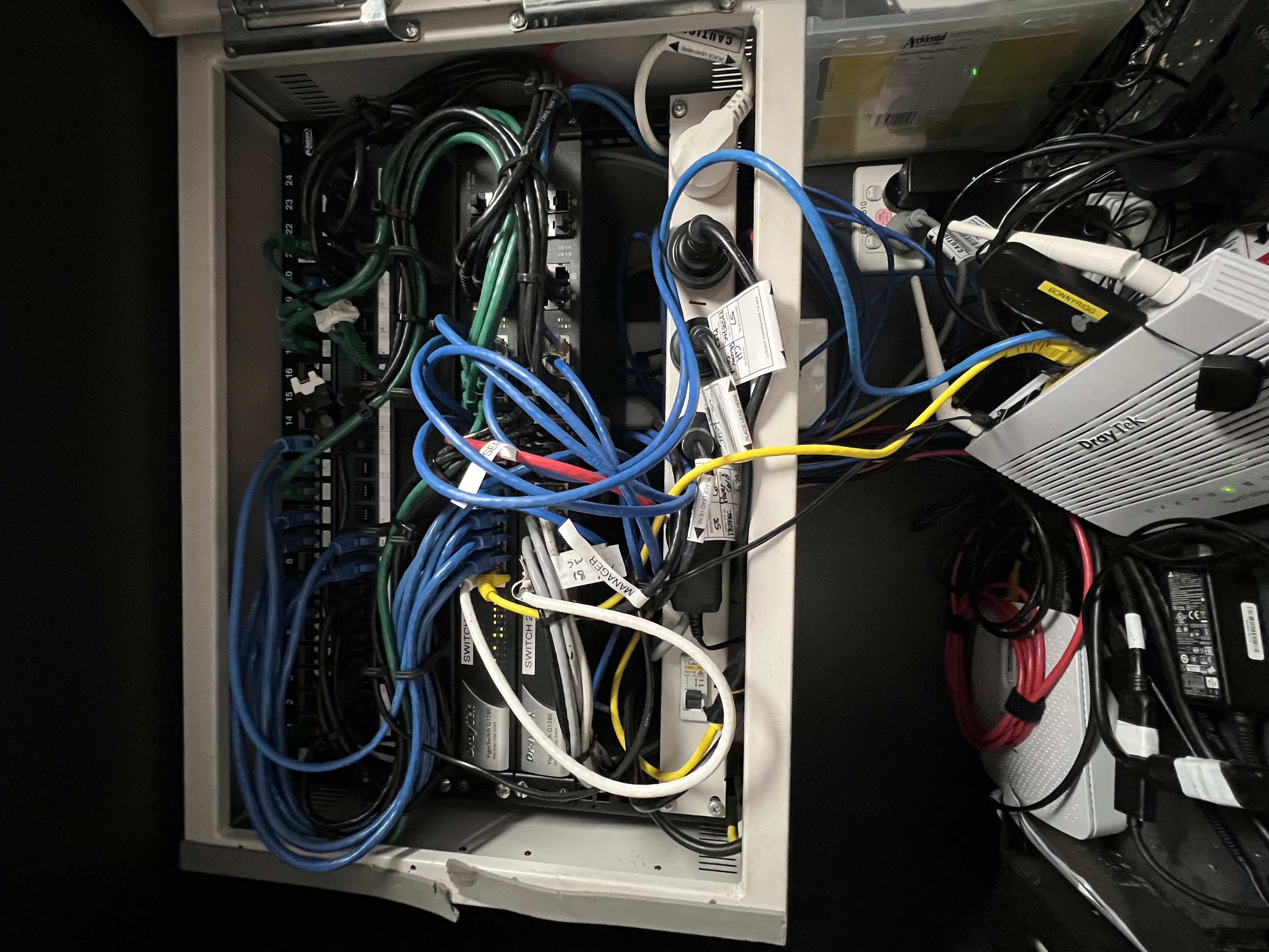 Before — retail network cabinet chaos, no documentation, no VLAN, cables everywhere